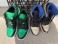Both pairs of Nike Air Jordan sneakers side by side showing color and condition differences