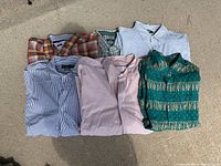 Overview photo of six folded shirts in different colors and patterns including plaid, checkered, and striped