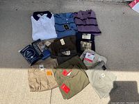 Full lot showing 3 polo shirts, 4 pairs of shorts, packaged socks and underwear.