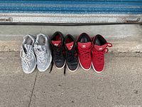Three pairs of athletic shoes lined up side by side showing the left and right shoe of each pair from above.