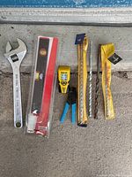 Photo showing the entire lot of used hand tools arranged side by side on a gray surface.