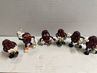 Photo showing all 6 California Raisins figurines lined up, different poses and accessories visible.