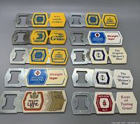 Top view of 10 vintage Molson can openers showing various beer brand logos and slogans printed on wooden handles, attached to metal openers.