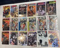 Photo showing all 18 comic books laid out in three rows; titles visible including Superman, Outlaw Nation, Ghost, KISS 4K, and Oceased series.