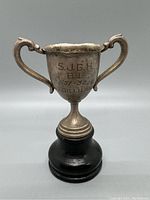 Front view of mid-century metal trophy cup with engraving