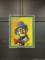 Front view of the vintage clown oil painting showing colorful portrait with signature and metal frame.