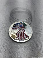 Obverse side of coin showing colorized Liberty figure with American flag motif and year 2000.