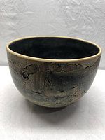 Front and side view of the bowl showing textured exterior with earthy colors and light rim