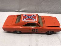 Side view of the orange General Lee model car showing the Confederate flag decal on the roof and '01' on the door.