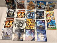 Overview of 19 Nintendo DS game instruction booklets arranged on a surface.