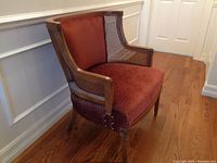 Front quarter view showing wood frame, cane side panels, upholstered seat and back