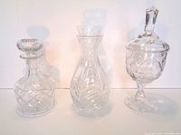 Crystal decanter with stopper, crystal carafe, and covered dish with pedestal and pointed stopper.