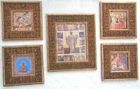 Full view of five framed icon prints arranged on wall, one large center frame and four smaller frames around it