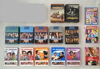 Various TV series DVD boxed sets laid flat showing covers and spine details including Carnivale, West Wing, Jeffersons, Get Smart, Facts of Life.