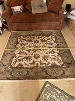 Full view of the rectangular carpet rug with measuring tape across showing width near 4 feet 9 inches