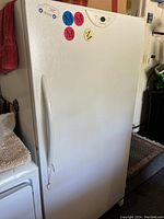 Front view of closed freezer showing overall condition and door-mounted magnets.