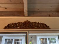 Full view of large wood carved panel mounted above door frame