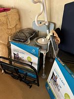 Photo showing Extend-A-Rail boxes, walker, wheelchair backrest, footrest, and other black accessories grouped together in corner.