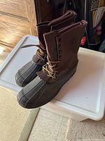 Pair of brown leather and black rubber boots showing good condition.