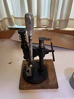 Front side of vintage mechanical hand press including lever handle and spring