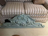 Front view of the large resin wall hanging showing detailed scroll and floral design in distressed finish.