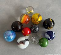 Top-down view showing all 12 marbles arranged in a cluster with visible details of colors and swirls.