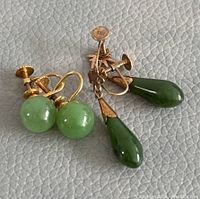 Both pairs of screw-back earrings displayed, showing round and teardrop jade drops.