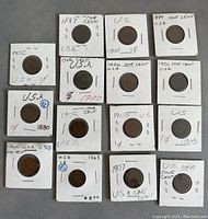 Fifteen collectible U.S. pennies inside white cardboard holders labeled with year and denomination