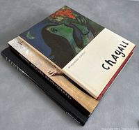 Three stacked art reference books showing covers and spines including Chagall, Henry Moore Remembered, and Lalique titles.