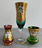 Front view of three vintage Bohemia Czech vases showing gold and colored glass with hand-painted floral designs