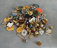 Pile of assorted collectible pins, brooches, and pendants with varied colors and designs