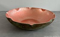 Side view of handmade bowl showing hammered texture and greenish patina on exterior with copper tone on interior