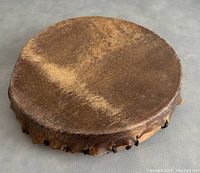 Top view of the drum showing natural brown hide surface with minor wear and natural texture with fur remnants.