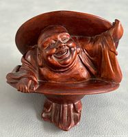Front view of hand carved wooden Happy Buddha figurine showing joyful face and wide brim hat detail.