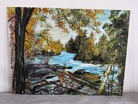 Full view of the original signed landscape painting showing river, trees, and rocks.