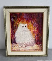 Frontal photo of the framed painting showing a fluffy white cat on a vibrant abstract background. The painting is signed by Dilek Degerli.