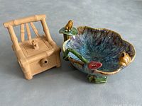 Photo of the pottery bamboo chair shaped teapot with spout and stamped base, showing the natural clay texture.