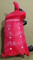 Red storage bag with white printed instructions for inflating adult inflatable bed.