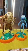 Both Hopper and Flik motion sensor toys standing on orange bases, showing size and detail