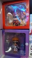 Shows Elastigirl figure in orange Incredibles 2 box and Moonwalker figure in purple Fortnite box through clear window.