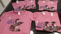 Seven pink Gildan t-shirts with duck graphics, folded and laid out together to show quantity and sizes.