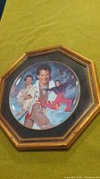 Octagonal framed collector plate featuring multiple illustrations of figure skater Kurt Browning in action and portrait style.