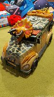 Toy van with dinosaur-themed military camouflage paint and molded details