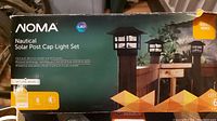 Box for NOMA Nautical Solar Post Cap Light Set showing product branding and intended use on fence posts.