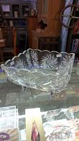Angle view of clear crystal glass bowl showing pinwheel pattern and scalloped rim.