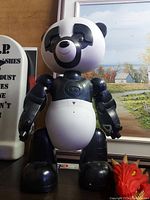 Robot panda toy figure in black and white, shown standing upright, highlighting its facial features and mechanical limbs.