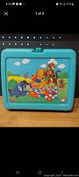 Front view of the blue plastic Winnie the Pooh lunch box featuring a picnic scene with Pooh, Tigger, and Eeyore.