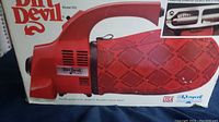 Photo of Dirt Devil Model 103 handheld vacuum cleaner showing the side profile with the cloth collection bag and branding.