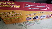 Box with printed text describing the grabber tool, showing its name and function to extend reach nearly 3 feet