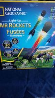 Front packaging of the National Geographic Light-Up Air Rockets kit, showing the product branding, rocket image with light effects, and usage suggestions.
